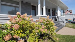 A two-story house with a porch, a garage, and a driveway. - Charming 1901 Home, Modern Updates, Near Lake Superior (Duluth)
