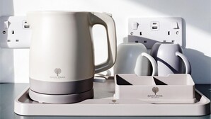 Eine Kaffeemaschine mit Tassenhalter und einer Mehrfachsteckdose inklusive USB-Anschlüssen.