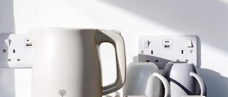 Una cafetera con portavasos y una regleta con puertos USB.
