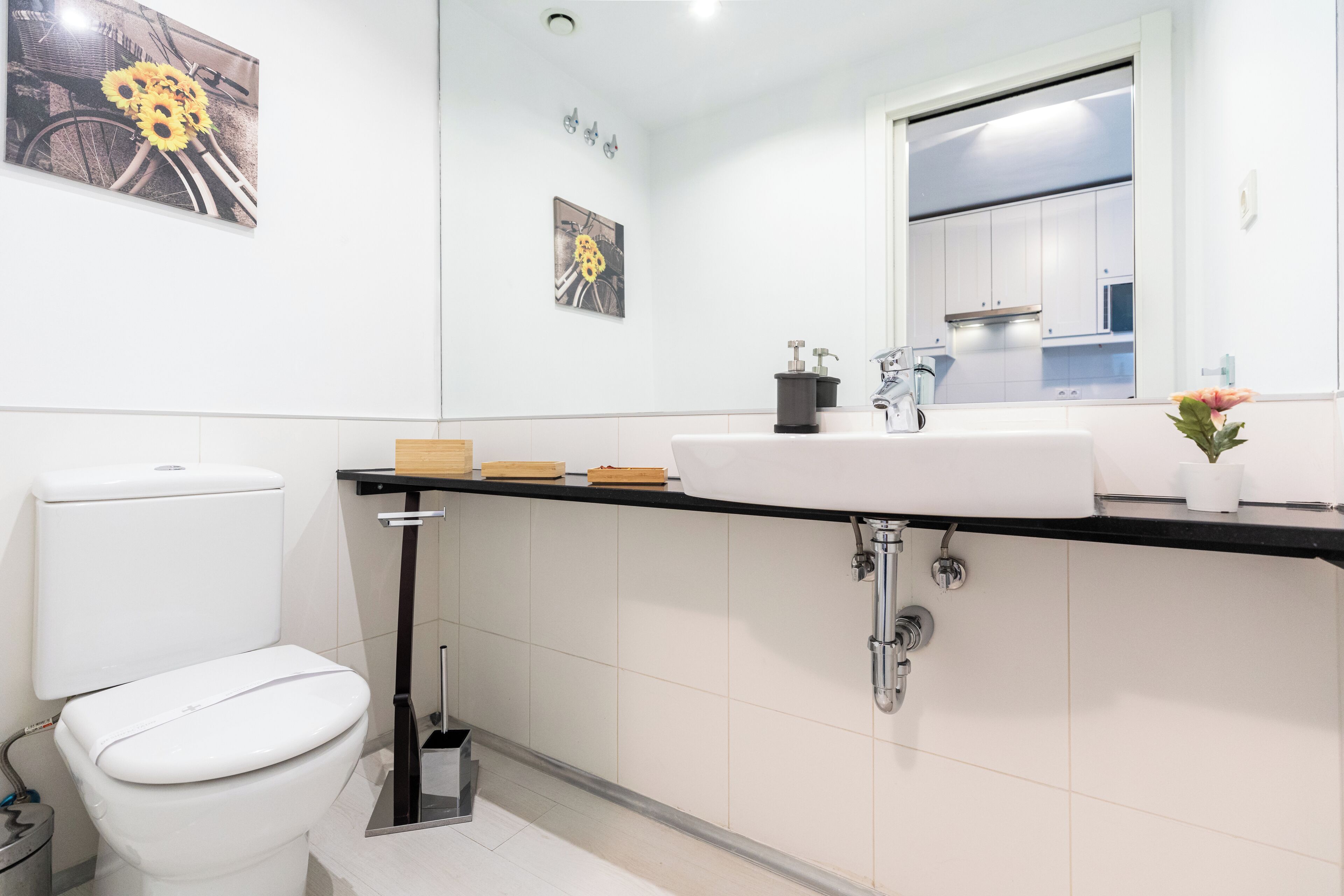 Ein modernes Badezimmer mit Toilette, Waschbecken und Spiegel.