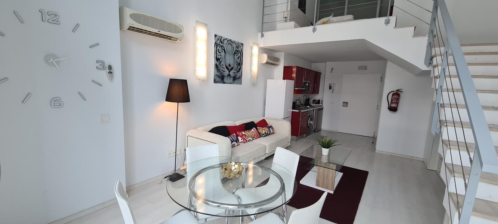 A modern apartment with a living area, kitchen, and dining space.