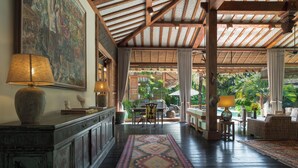 A spacious lobby with a high ceiling, wooden beams, a large painting, a reception desk, and a view of the outdoor garden. - A serene luxury villa in Berawa, Canggu! (Canggu)