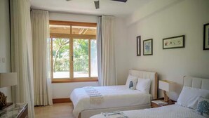 Ein Hotelzimmer mit zwei Betten, einem Schreibtisch und einem Fenster mit Vorhängen.