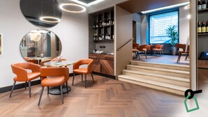 A modern interior with a dining area, a wine rack, and a staircase leading to an outdoor area. - Hotiday Roma Trevi (Rome)