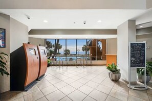 A hotel lobby with a pool view, a sauna area, and a bar. - Cozy 1-Bedroom Oceanfront Condo in Myrtle Beach (Myrtle Beach)