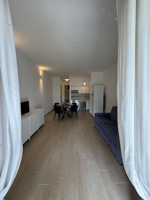 En moderne lejlighed med spiseplads, køkken og opholdsstue.