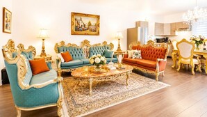A luxurious living room with ornate furniture, a coffee table, and a dining area with a chandelier. - Exquisite 6 Bedroom Loft - Downtown Victorian charm with parking included (Montréal)