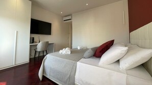 Et moderne hotelværelse med seng, skrivebord og tv.