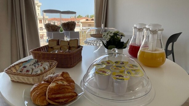 Un buffet de petit-déjeuner comprenant du pain, des viennoiseries et des boissons.