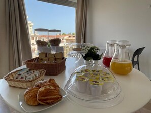 Um buffet de café da manhã com pães, doces e bebidas.