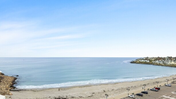 A coastal view with a beach, parking area, and a residential area in the background. - Big-Group Lock-Off Condo | 1BR + Resort Room | Sleeps a Crowd (York)
