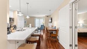 Une cuisine moderne avec un îlot central, une table à manger en bois et des chaises.