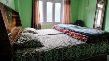 A bedroom with a bed, pillows, a window, and a mirror.