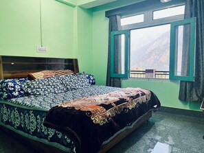 A bedroom with a bed, a window, and a view of mountains. - Prifrost Homesaty (Sangla)