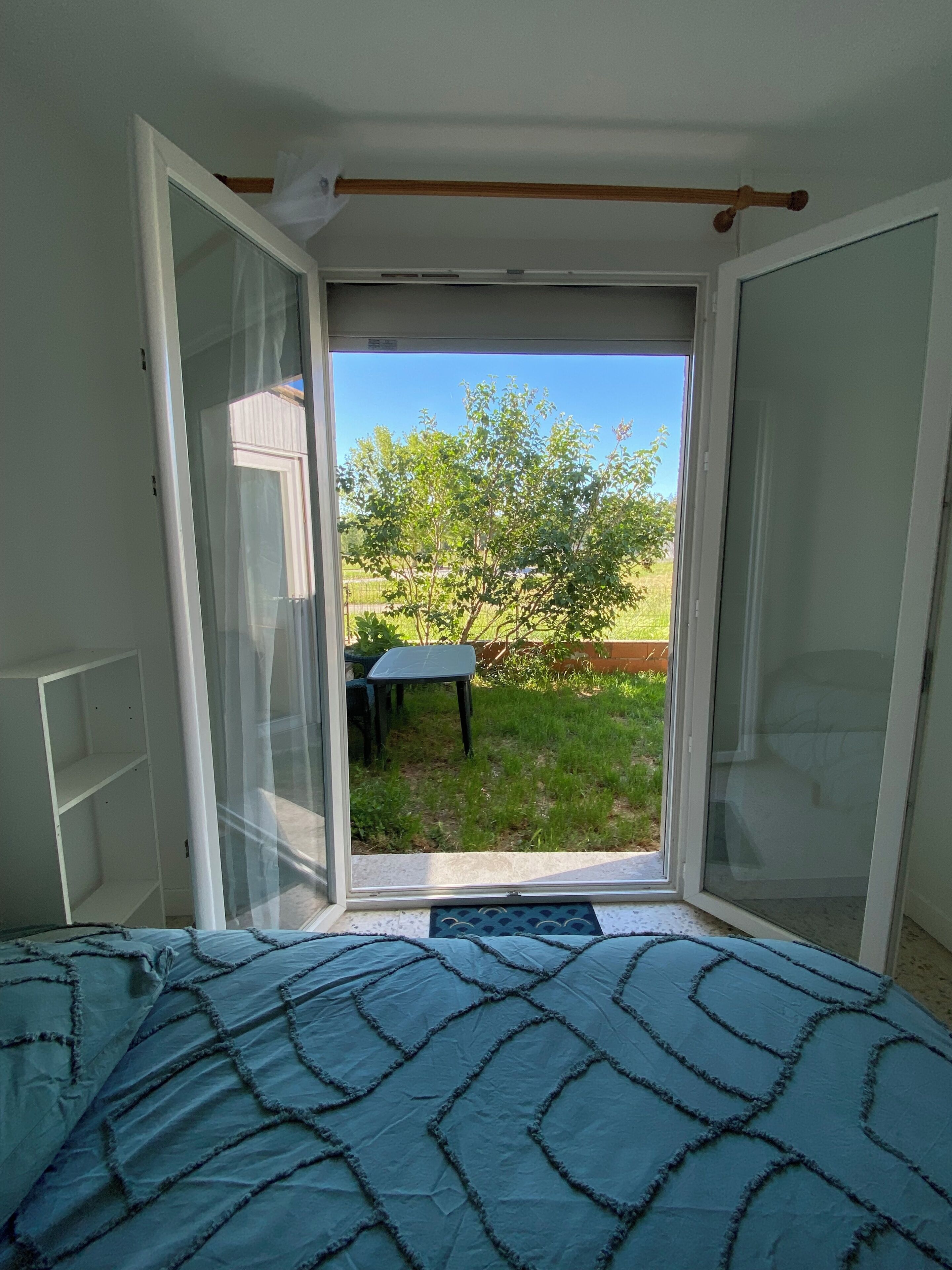 Ein Schlafzimmer mit einem Bett und einer Schiebetür zu einem Garten.