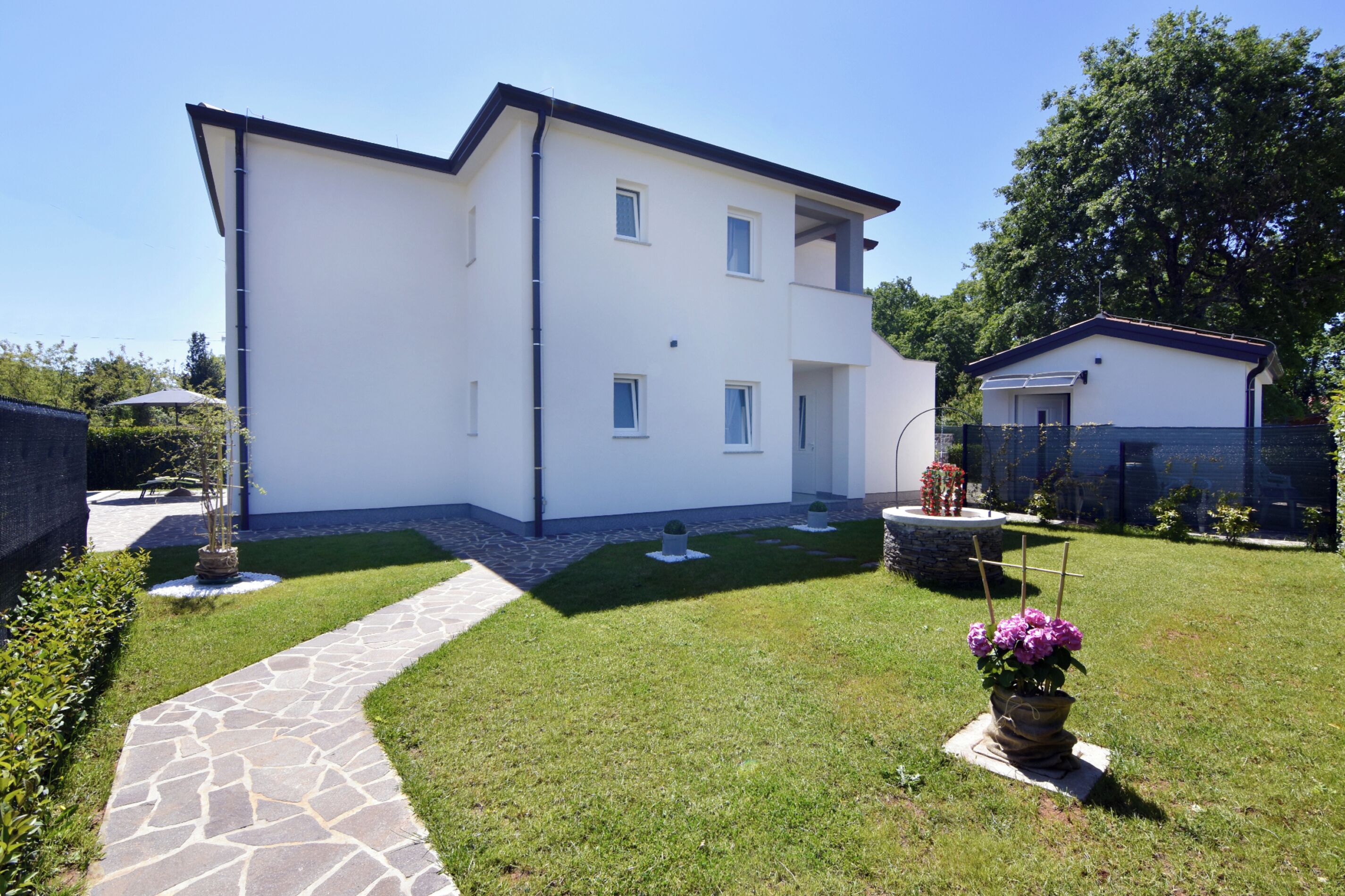 A two-story white building with a stone pathway leading to the entrance.