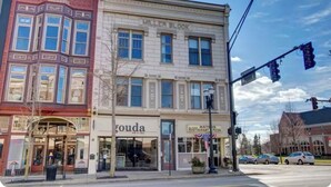 Une vue de rue avec un immeuble portant l’inscription « Miller Block » et un restaurant appelé « Matsos Restaurant & Pizza » situé au rez-de-chaussée.