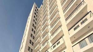 A high-rise building with multiple balconies and large windows. - Luxury Apartment with Pool Gym & Free Parking at Equiti Gates Jebel Ali (Dubai)