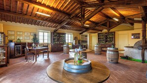 A rustic interior with wooden barrel tables, a bar area, and a wine rack. - Panoramic Tuscan villa with infinity pool, exclusive use, private garden (Montecarlo)