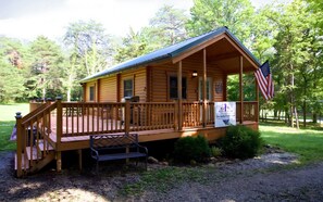 A wooden cabin with a porch, an American flag, and a sign that reads "The Julia Fish Cabin."