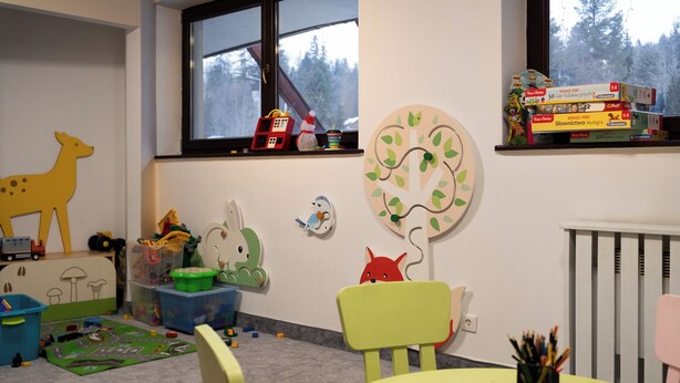 A child's playroom with toys, a green chair, a table, and educational materials. - Butorowy Residence Kościelisko by Downtown Apartments (Kościelisko)