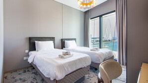 A hotel room with two beds, a chandelier, a view of a Ferris wheel, and a large window. - Full Sea View!, 2br in JBR (Dubai)