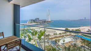 A balcony with a view of a beach, a Ferris wheel, and a marina. - Full Sea View!, 2br in JBR (Dubai)