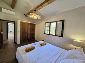 Ein Schlafzimmer mit einem großen Bett, einem Holzschrank und einem Fenster mit Blick.