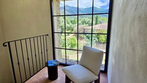 Ein Balkon mit Stuhl, Tisch und Blick auf eine Berglandschaft.