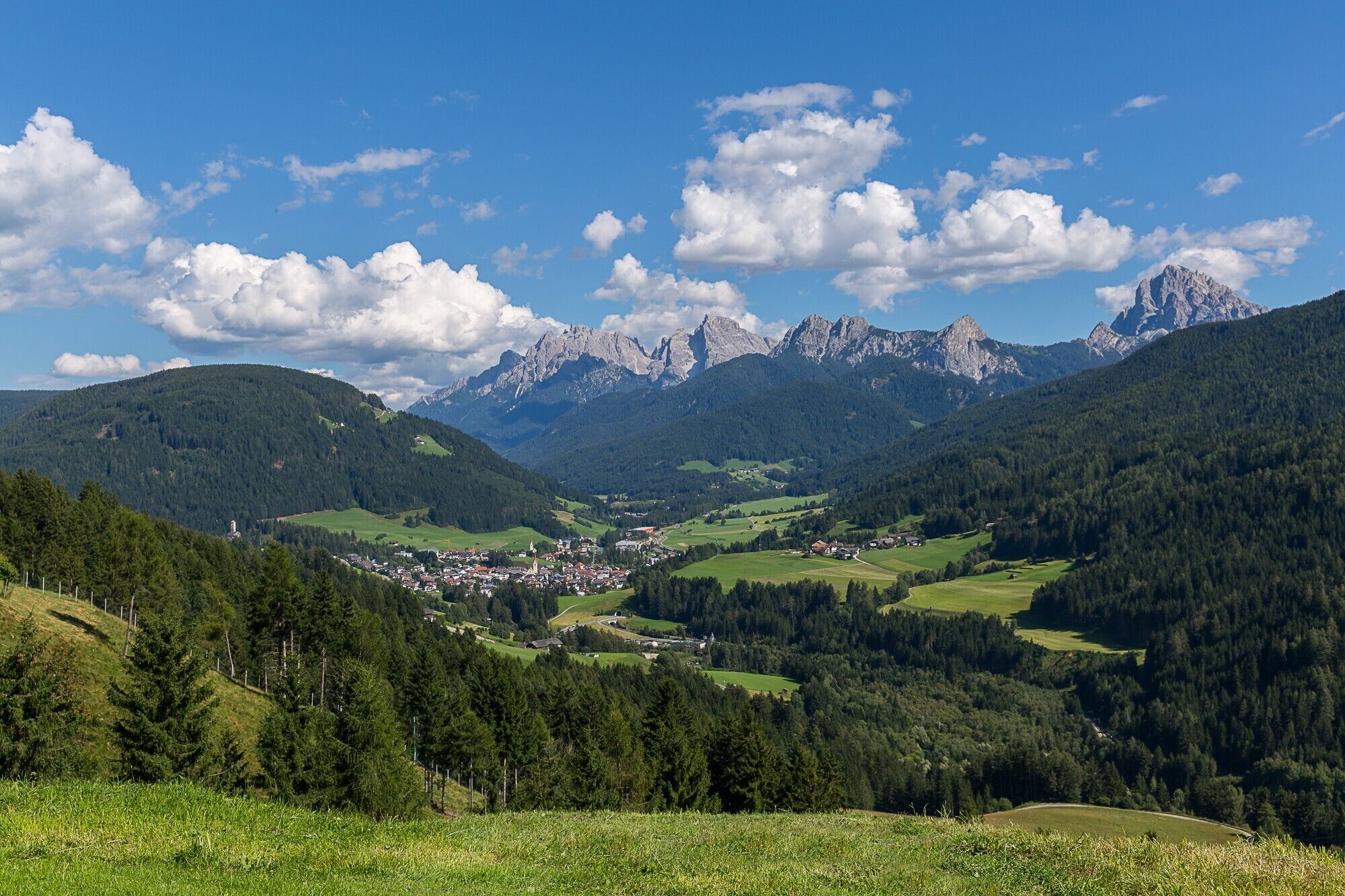 Eine bergige Landschaft, in der ein Städtchen im Tal liegt.