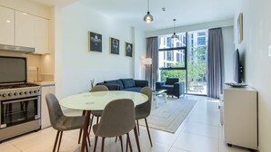 Um apartamento moderno com cozinha, área de refeições e sala de estar.