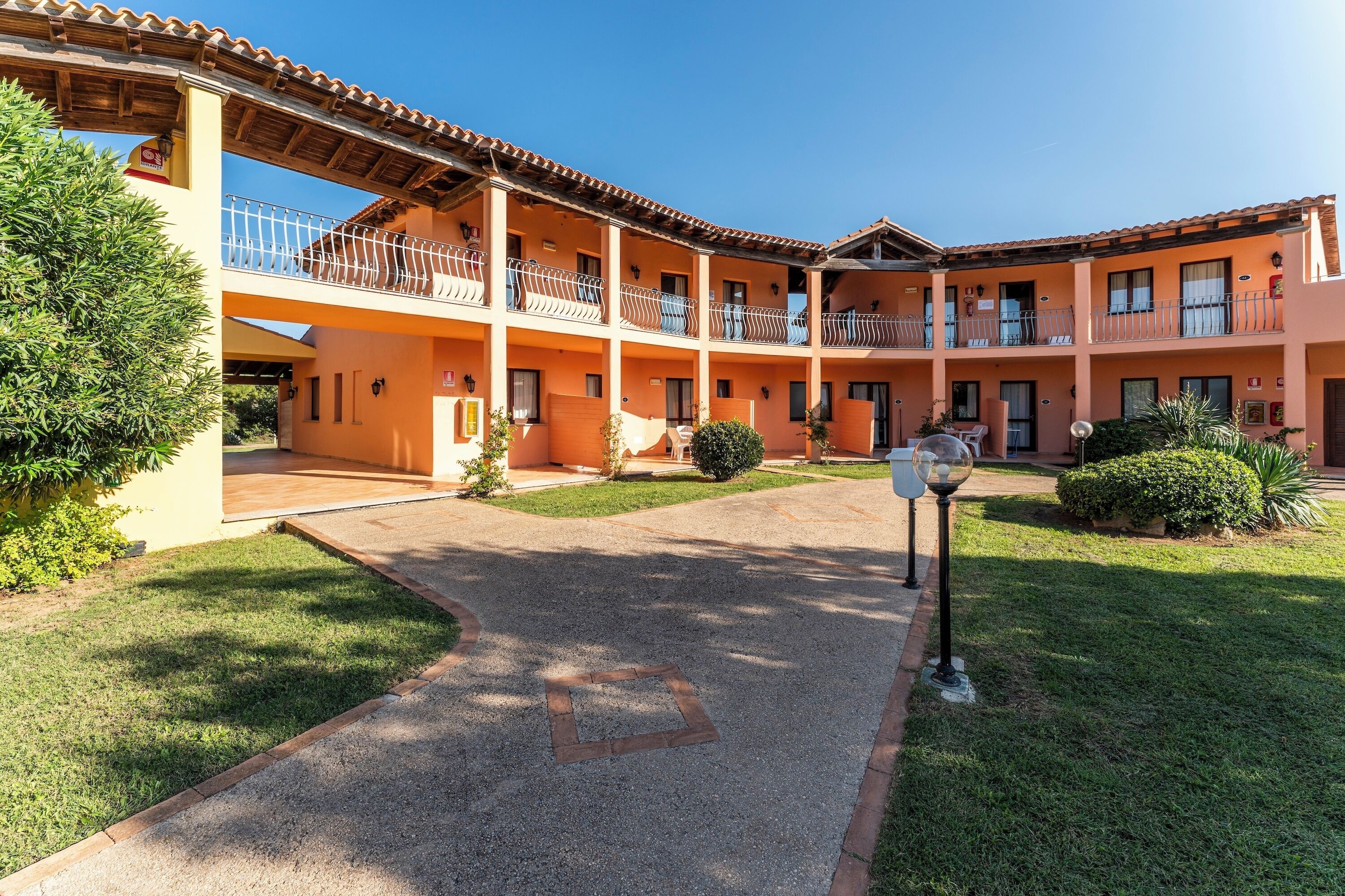 A courtyard with a building featuring multiple balconies, a central open space, and a small garden area.