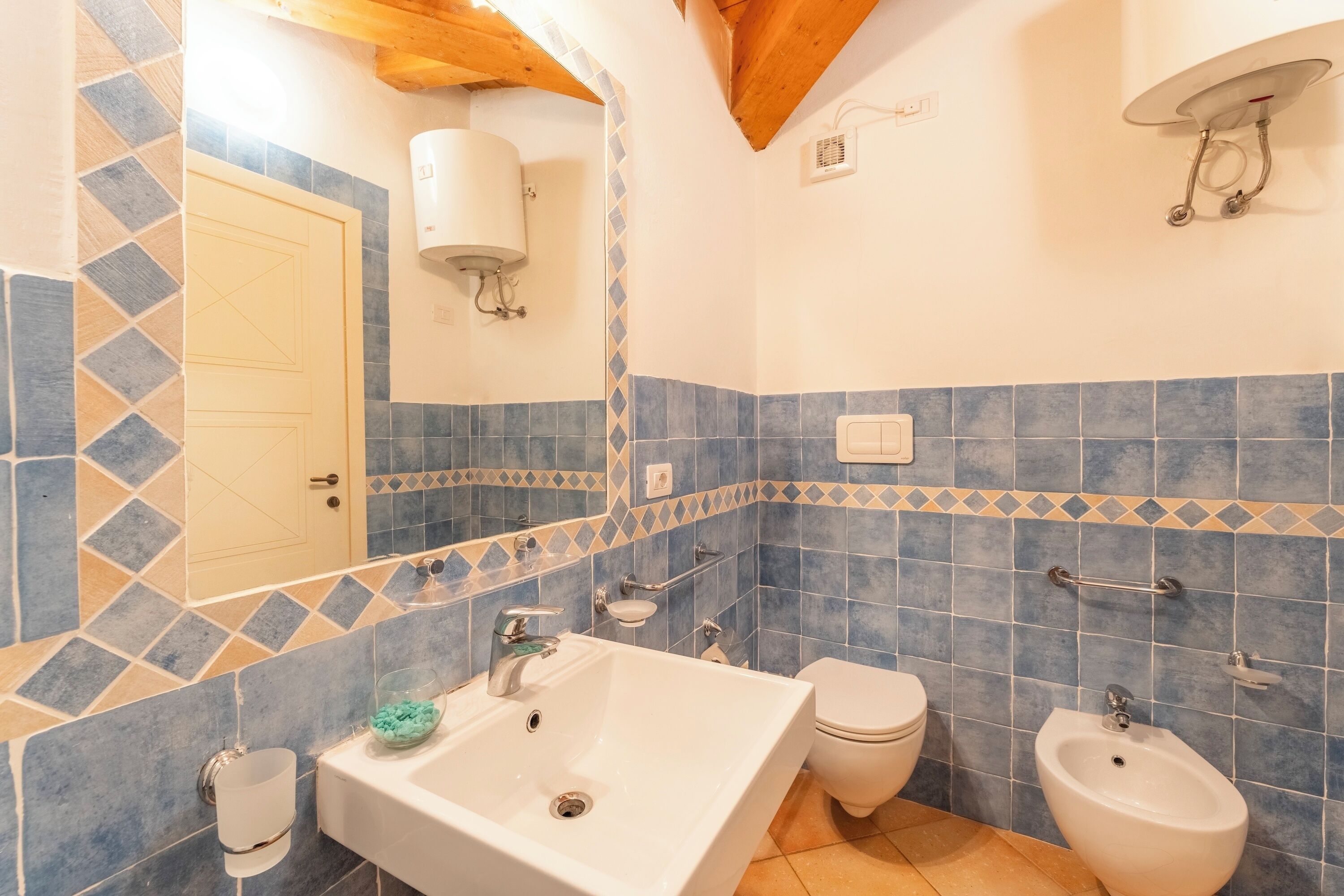 Ein Badezimmer mit Waschbecken, Toilette, Bidet und Spiegel.