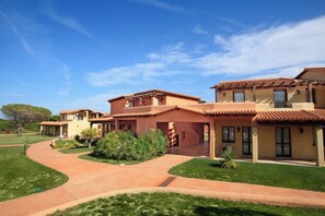 A large, multi-story building with a courtyard and a curved driveway. - Cozy Studio With Shared Pool (Aglientu)