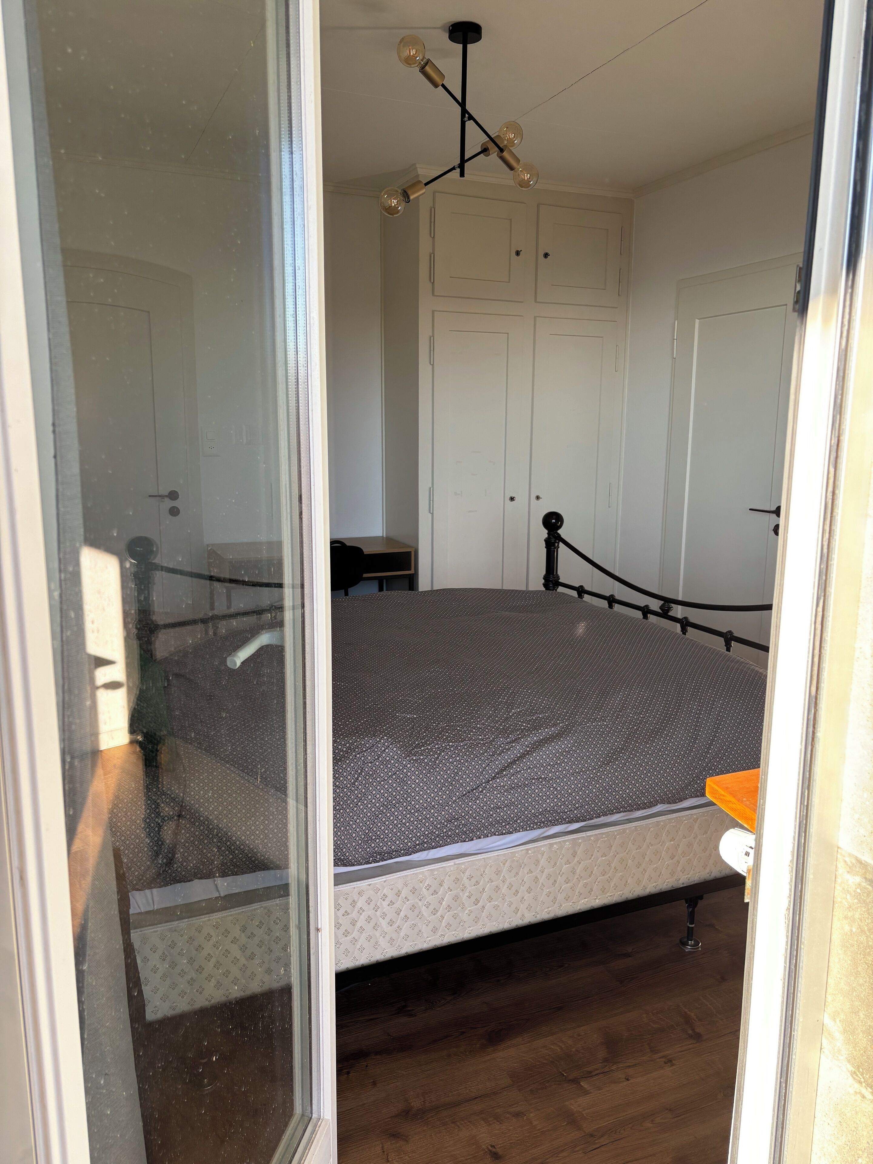 Ein Schlafzimmer mit einem Bett, einem Kleiderschrank und einer Deckenleuchte.