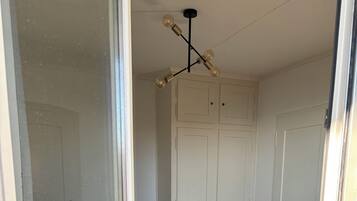 Ein Schlafzimmer mit einem Bett, einem Kleiderschrank und einer Deckenleuchte.