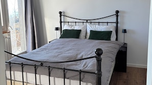 Ein ordentlich eingerichtetes Schlafzimmer mit Bett, Nachttischen und einer Deckenleuchte.