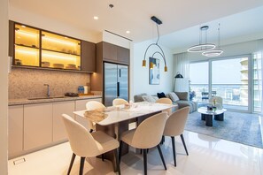 Una cocina moderna con horno integrado y comedor con mesa y sillas de mármol.