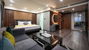 Een moderne hotelkamer met een bed, bank en een salontafel met een dienblad thee en kopjes.