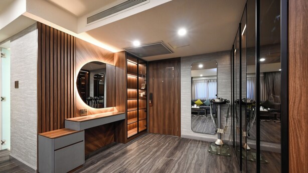 Een modern interieur met een houten wastafelmeubel, inbouwplanken en een ronde spiegel.