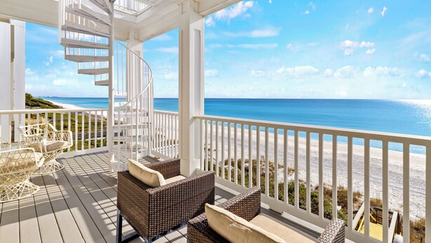 A covered outdoor area with a spiral staircase, wicker furniture, and a view of the beach. - Rooftop Deck, Paddle Boards, Gulf Front on 30A (Inlet Beach)
