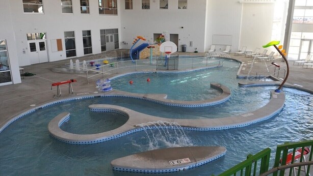 Piscina interna com várias pistas, um tobogã e uma cesta de basquete.