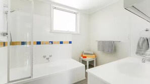 Ein modernes Badezimmer mit Duschkabine aus Glas, einer Badewanne und einem Waschbecken.