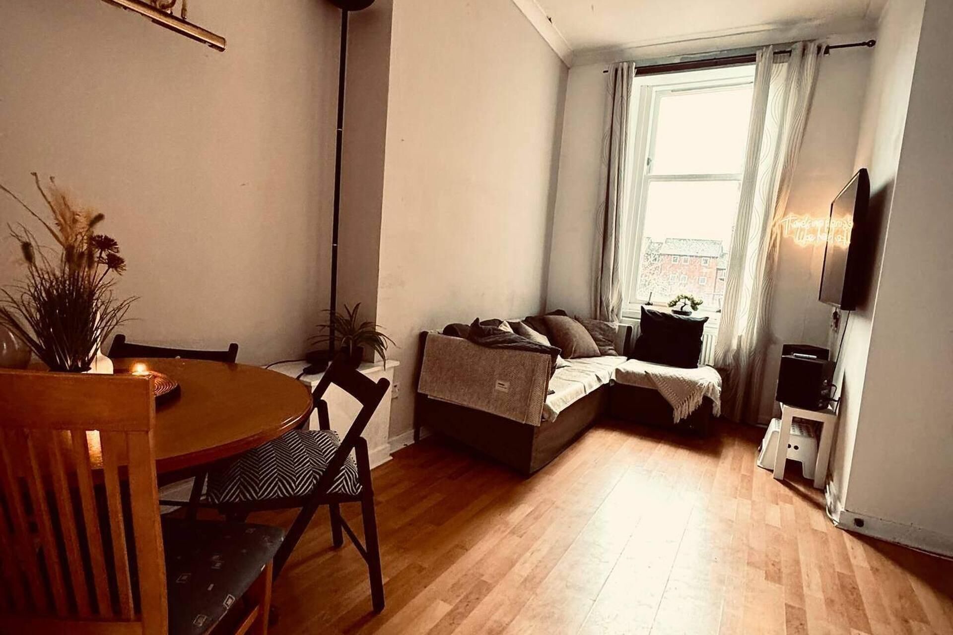 A small, cozy room with a bed, a desk, and a chair.