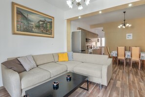 Un salon avec un canapé, une table basse et un tableau accroché au mur.