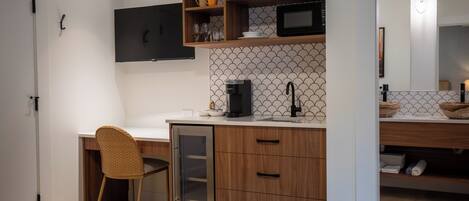 A compact kitchen with wooden cabinets, a microwave, and a coffee maker.