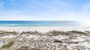 A beach with a sandy path leading to the ocean, a wooden fence, and a clear sky. - Perdido Towers West 606 (Pensacola)