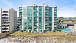 A modern multi-story hotel with a pool area, located near a beach. - Perdido Towers West 606 (Pensacola)