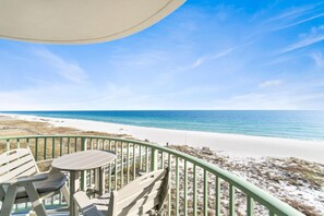 Un balcon avec vue sur une plage et l’océan.