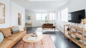 Una sala moderna con un sofá, una mesa de centro y un televisor en la pared.